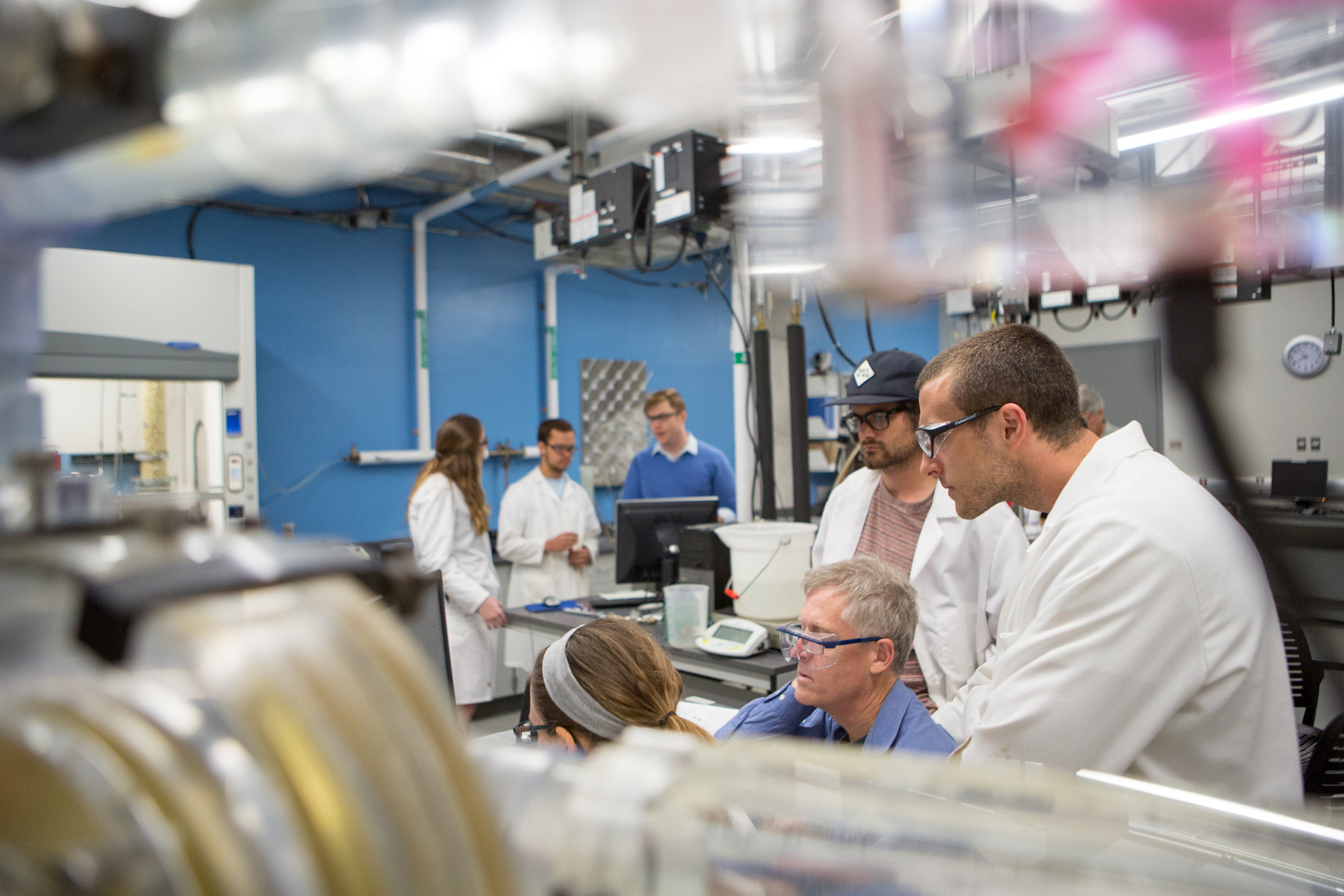 Three students working on an experiments in a laboratory with their mentor